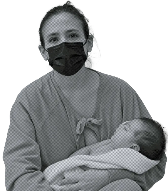 Una madre con mascarilla sostiene a su bebé recién nacido