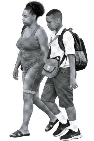 Una madre y su hijo caminan hacia la escuela